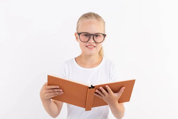 Bildung, Menschen, Kinder und Schulkonzept - Schüler mit Brille halten Buch in der Hand auf weißem Hintergrund — Stockfoto