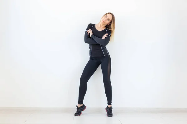 Gente, fitness y concepto deportivo - Mujer hermosa en forma vestida con ropa deportiva posando sobre fondo blanco —  Fotos de Stock