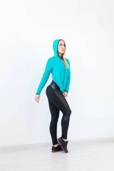 Gente, fitness y concepto deportivo - Hermosa modelo en ropa deportiva posando sobre fondo blanco —  Fotos de Stock