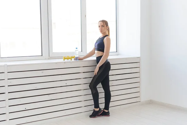 Entrenamiento, fitness y concepto deportivo - mujer bastante deportiva de pie cerca de la ventana en el gimnasio —  Fotos de Stock