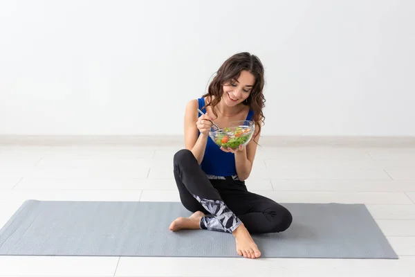 Mode de vie sain, personnes et concept sportif - Femme de yoga avec un bol de salade de légumes — Photo