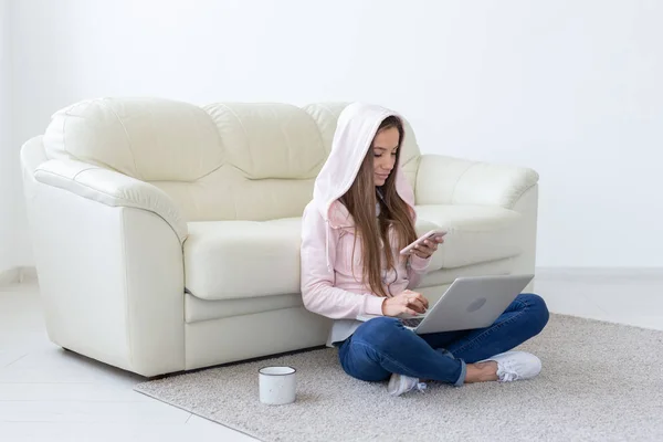Concept de travail, de confort et de personnes - jeune femme travaillant à la maison, buvant du thé et bavardant dans le netbook — Photo