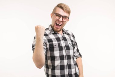 İnsanlar, duygular ve zafer kavramı-gömlek giyinmiş heyecanlı ve mutlu genç adam beyaz arka planda yumruk yukarı gösteren.