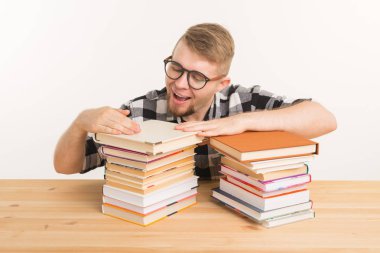 İnsanlar, bilgi ve eğitim kavramı - kitaplar ile tahta masada oturan adam gülümseyen