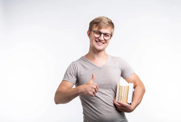 Concepto de personas, conocimiento y educación - Retrato de un estudiante vestido con una camiseta gris sosteniendo libros en sus manos — Foto de Stock