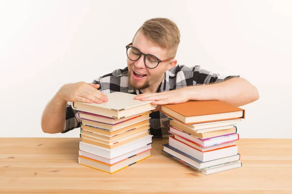 Persone, conoscenza ed educazione - uomo sorridente seduto al tavolo di legno con libri — Foto Stock