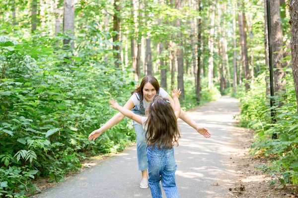 Familia y concepto de la naturaleza - Mujer joven con niña se divierten al aire libre —  Fotos de Stock