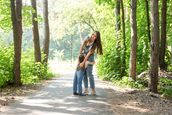 Οικογένεια, φύση, άνθρωποι έννοια - μητέρα και κόρη αγκαλιάζει στο πάρκο — Φωτογραφία Αρχείου