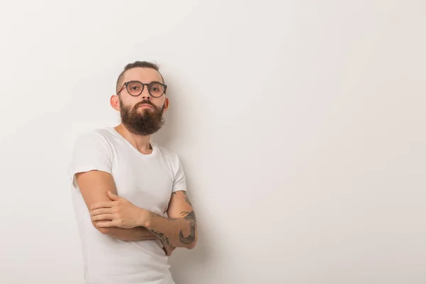 Hipster, concepto de la gente - hipster tipo con gafas con los brazos cruzados sobre un fondo blanco —  Fotos de Stock