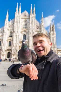 Kış seyahat, tatil ve kuşlar kavramı - selfie güvercinler yakınındaki Milan Katedrali Duomo di Milano, İtalya ile alarak genç komik adam.
