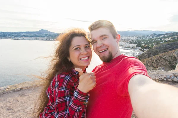 Koncepcja podróży, wakacji i wczasów - para piękny posiadające zabawy, biorąc selfie, szalony twarze emocjonalne i śmiejąc się. — Zdjęcie stockowe