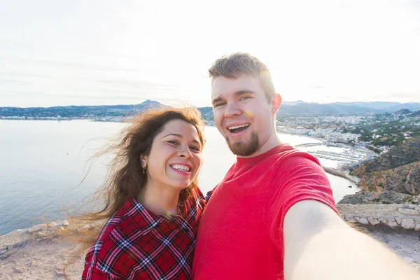 Viagens, férias e férias conceito - casal feliz tomando selfie sobre bela paisagem — Fotografia de Stock