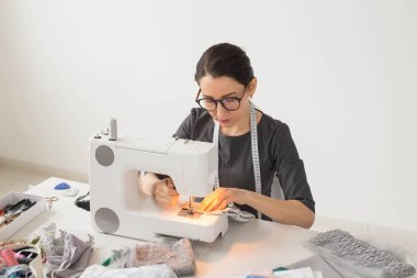 İnsanlar, terzi ve moda kavramı - portre çalışma yer moda tasarımcısı dikiş makinesi ile yakından