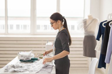 Terzi, moda tasarımcısı ve terzi kavramı - genç kadın tasarımcı, bir elbise yaratma süreci