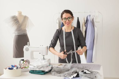 Terzi, moda tasarımcısı ve terzi kavramı - genç kadın tasarımcı güzel hafif kumaş keser