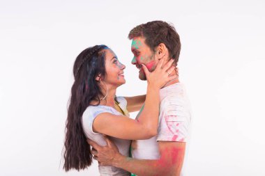 Tatil, bayram ve insanlar kavramı - mutlu çift yüzlerini beyaz arka plan üzerinde renkli cam tozu ile eğlenmek