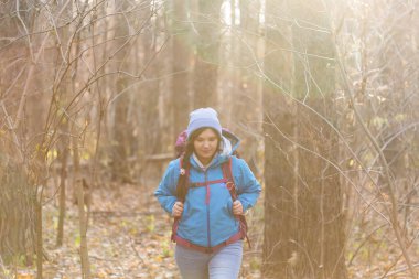İnsanlar, yürüyüş ve doğa kavramı - giyimli kadın mavi ceketli ormanda yürüyüş