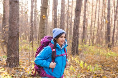 İnsanlar, yürüyüş ve doğa kavramı - giyimli kadın mavi ceketli ormanda yürüyüş