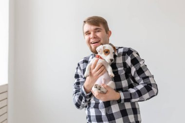 insanlar, hayvanlar ve köpekler kavramı - sarılma komik köpek yavrusu beyaz arka plan üzerinde genç adam