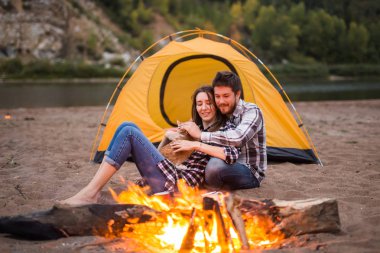 Kişi, turizm ve doğa kavram - bir ateşin yanında oturan adam embrace kadın