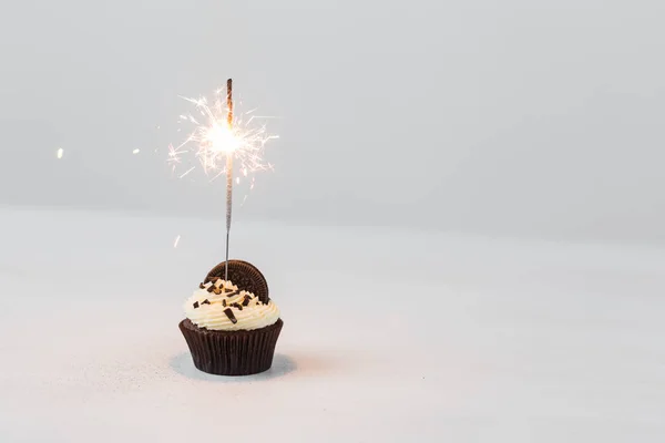 Cibo, festa e concetto di vacanza - Cupcake di compleanno con sparkler su sfondo bianco con spazio copia — Foto Stock
