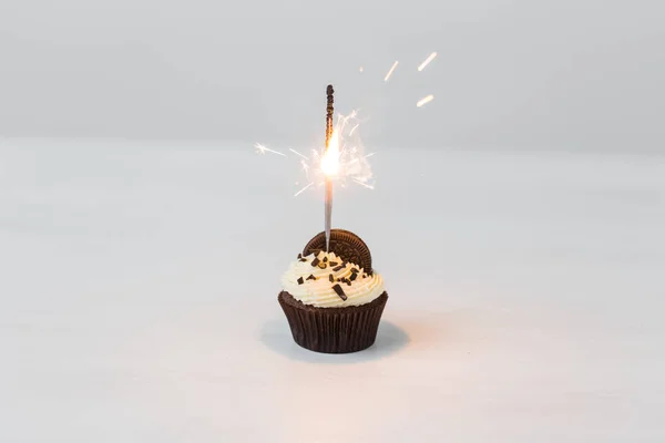 Cibo, festa e concetto di vacanza - Cupcake di compleanno con sparkler su sfondo bianco — Foto Stock