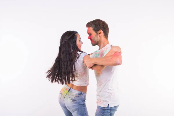 Férias, dança social, holi e conceito de pessoas - Casal feliz se divertindo e dançando bachata ou kizomba coberto de tinta sobre fundo branco — Fotografia de Stock