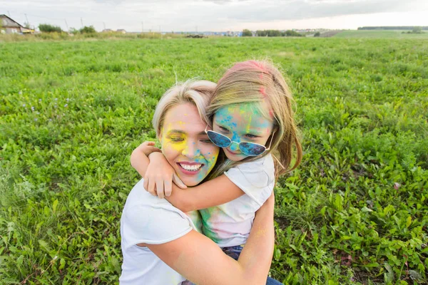 행복, Holi 축제와 공휴일 개념-어머니와 그녀의 딸 자연 배경 위에 미소 컬러 파우더로 덮여 — 스톡 사진