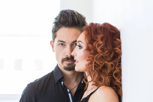 Pessoas e conceito de beleza - Retrato de tiro na cabeça de casal com rostos sérios sobre a parede branca — Fotografia de Stock