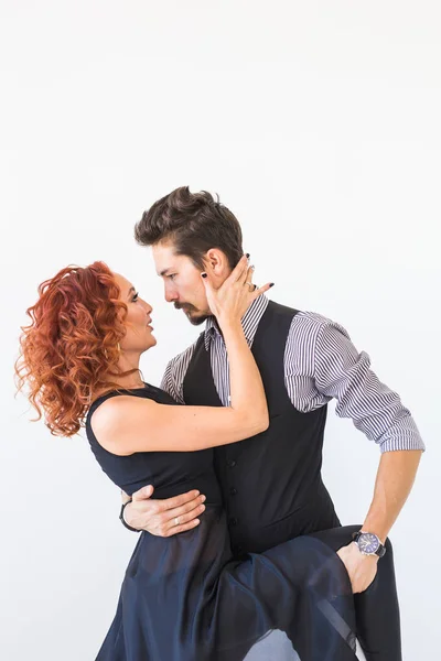 Dança social, bachata, kizomba, zouk, conceito de tango - Homem abraça mulher enquanto dança sobre fundo branco no estúdio — Fotografia de Stock