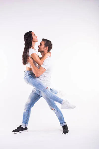 Casal jovem dançando bachata dança latina social, merengue, salsa. Dois pose elegância no fundo branco — Fotografia de Stock