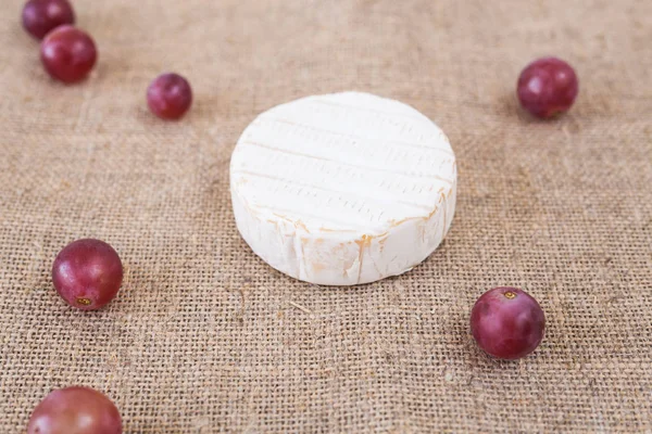 Brie of camembert kaas met druiven op rustieke achtergrond — Stockfoto