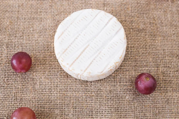 Queso brie o camembert con uvas sobre fondo rústico vista superior — Foto de Stock