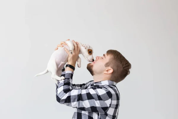 사람, 애완 동물 및 동물 개념-가까이 들고 젊은 남자의 잭 러셀 테리어 강아지 흰색 바탕에 — 스톡 사진