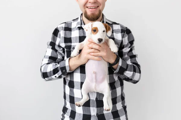Concepto de personas, mascotas y perros - primer plano del hombre abrazando divertido cachorro sobre fondo blanco — Foto de Stock