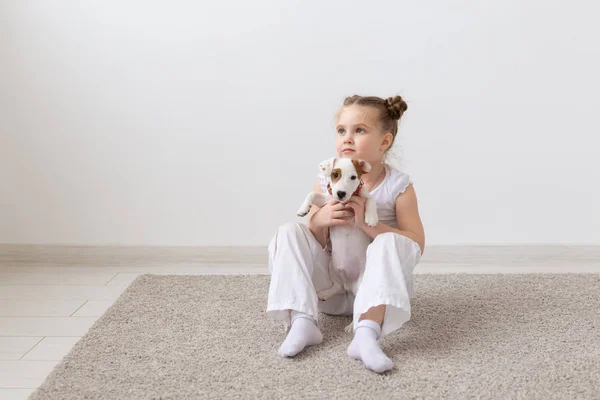 Mascotas, niños y concepto animal - Adorable niña y divertido cachorro divertirse —  Fotos de Stock