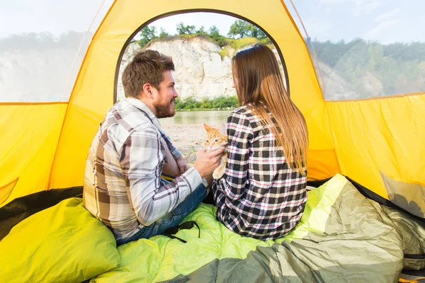Lidé, Letní turistika a příroda koncept - mladý pár v stan, pohled z uvnitř — Stock fotografie