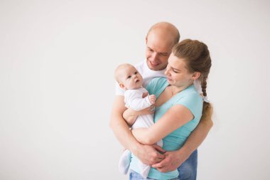 Gururlu anne ve baba yeni doğan bebek kızları kopya alanı ile beyaz arka plan üzerinde gülümseyen