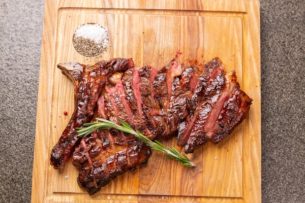Concepto de alimentos y carne de caballo - Carne asada en la tabla de cortar con comino —  Fotos de Stock
