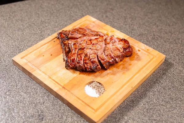 Élelmiszer- és ló hús koncepció - vágódeszka köményes sült hús — Stock Fotó