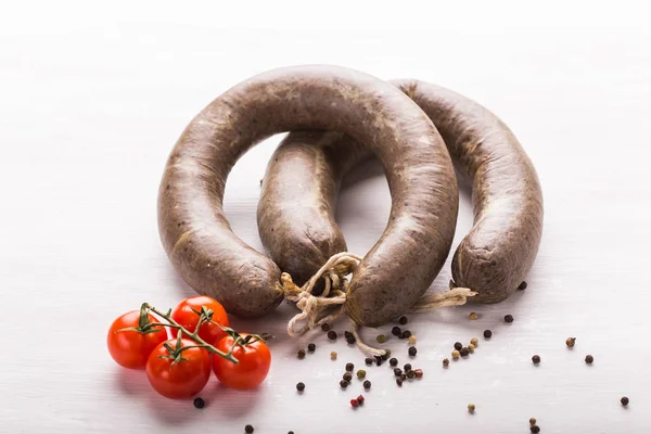 Food, horse meat and delicious concept - sliced sausage with tomato and pepper — Stock Photo, Image