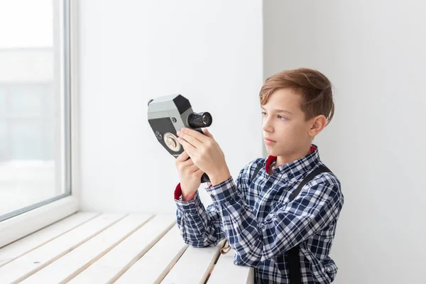 Fotógrafo, niños y el concepto de pasatiempo lindo adolescente posando con cámara retro sobre fondo blanco —  Fotos de Stock