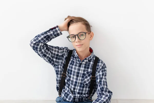 Tiener, kinderen en fashion concept - portret van jongen gekleed in plaid shirt poseren op witte achtergrond — Stockfoto