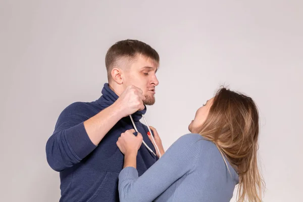 Personnes, violence domestique et concept de maltraitance - jeune homme menace sa femme avec son poing sur fond blanc — Photo