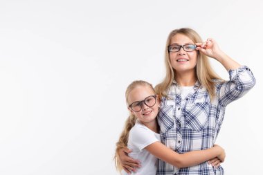 Mutlu genç anne ve moda gözlük gülen çocuk beyaz arka plan üzerinde eğlenmek