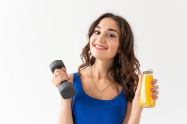 Spor, sağlıklı yaşam tarzı, insanlar kavramı - yakın çekim genç kadının elini ve bir şişe suyu beyaz zemin üzerine başka bir elinde bir dumbbell ile