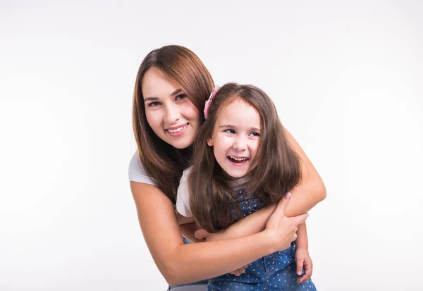 Conceito de maternidade, família e relacionamento - Mãe feliz e filha pequena se divertindo no fundo branco — Fotografia de Stock