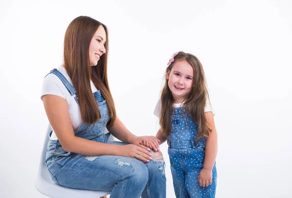 Concepto de familia, hijos y maternidad: la joven madre y su hija pasan tiempo juntas aisladas sobre un fondo blanco — Foto de Stock