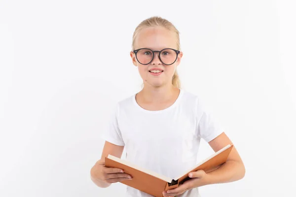 Bildung, Menschen, Kinder und Schulkonzept - Schüler mit Brille halten Buch in der Hand auf weißem Hintergrund — Stockfoto