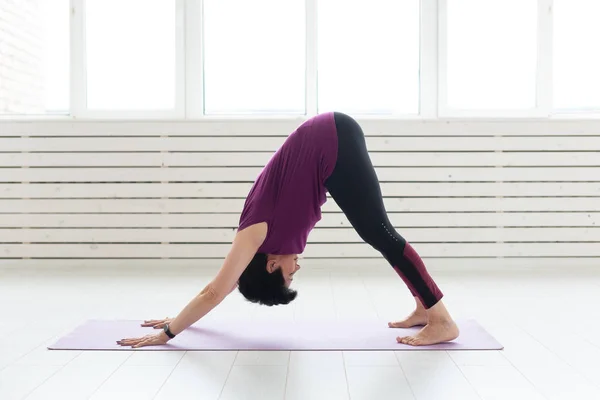 Estilo de vida saludable, personas y concepto deportivo - Mujer de mediana edad haciendo yoga —  Fotos de Stock